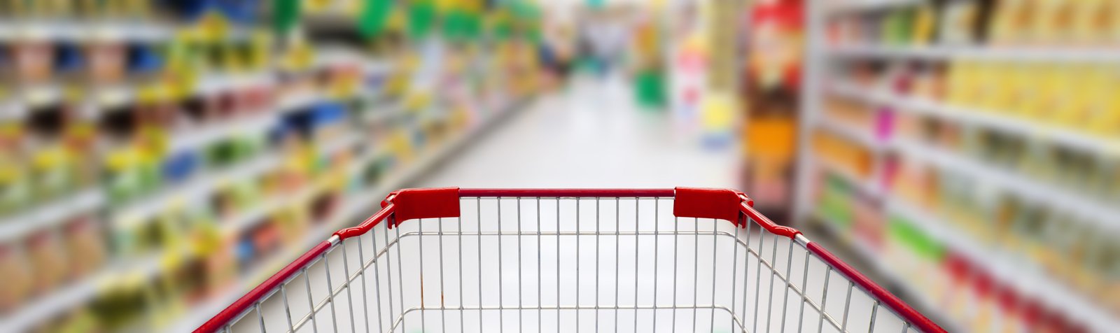 Front of a grocery cart against an out-focus grocery store aisle background